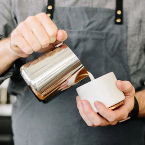 Barista lej pienu no pulētas nerūsējošā tērauda kannas, daļa no Espresso piederumiem un piena kannas, viss par kafiju.