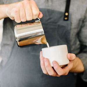 Barista lej pienu no pulētas nerūsējošā tērauda kannas, daļa no Espresso piederumiem un piena kannas, viss par kafiju.