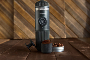 Melna pārnēsājama Nanopresso ar kafiju kapsulā un maltu kafiju, espresso piederumi no baristas un pārnēsājamas kafijas pagatavošanas ierīces.